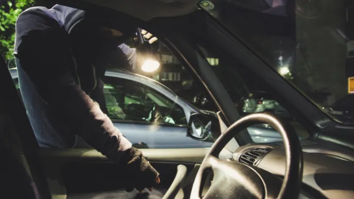 bezpečnostné označenie - zlodej sa vláme do auta na obrázku